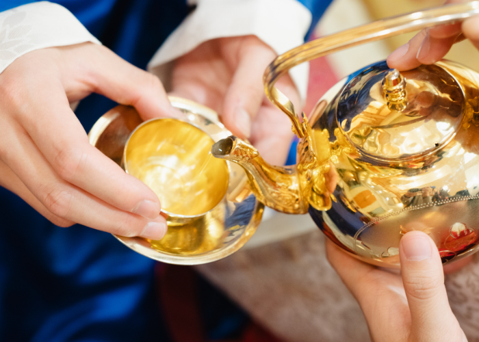 Tea ceremony - pouring tea into gold plated cups.